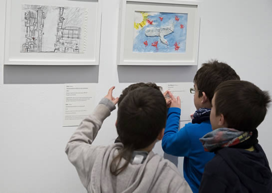 Niños contemplando y comentando las obras de la exposición