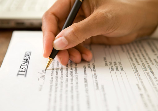 mano de una persona sosteniendo un bolígrafo sobre un documento