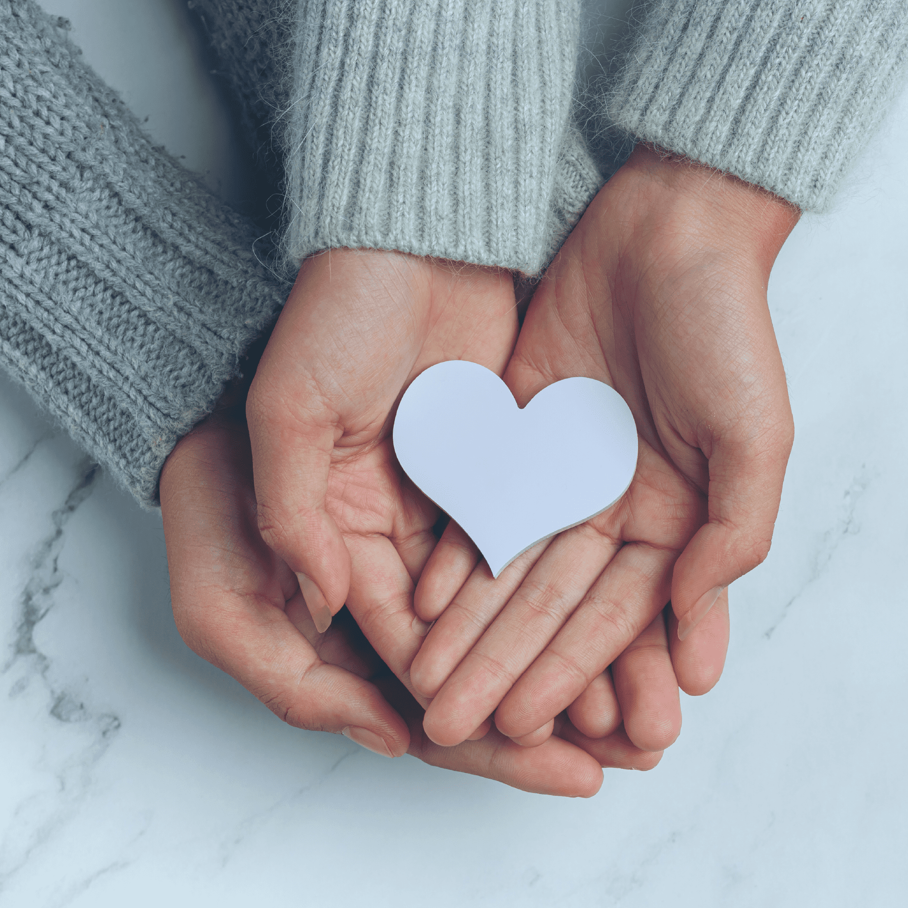 Manos sujetando un corazón de color violeta