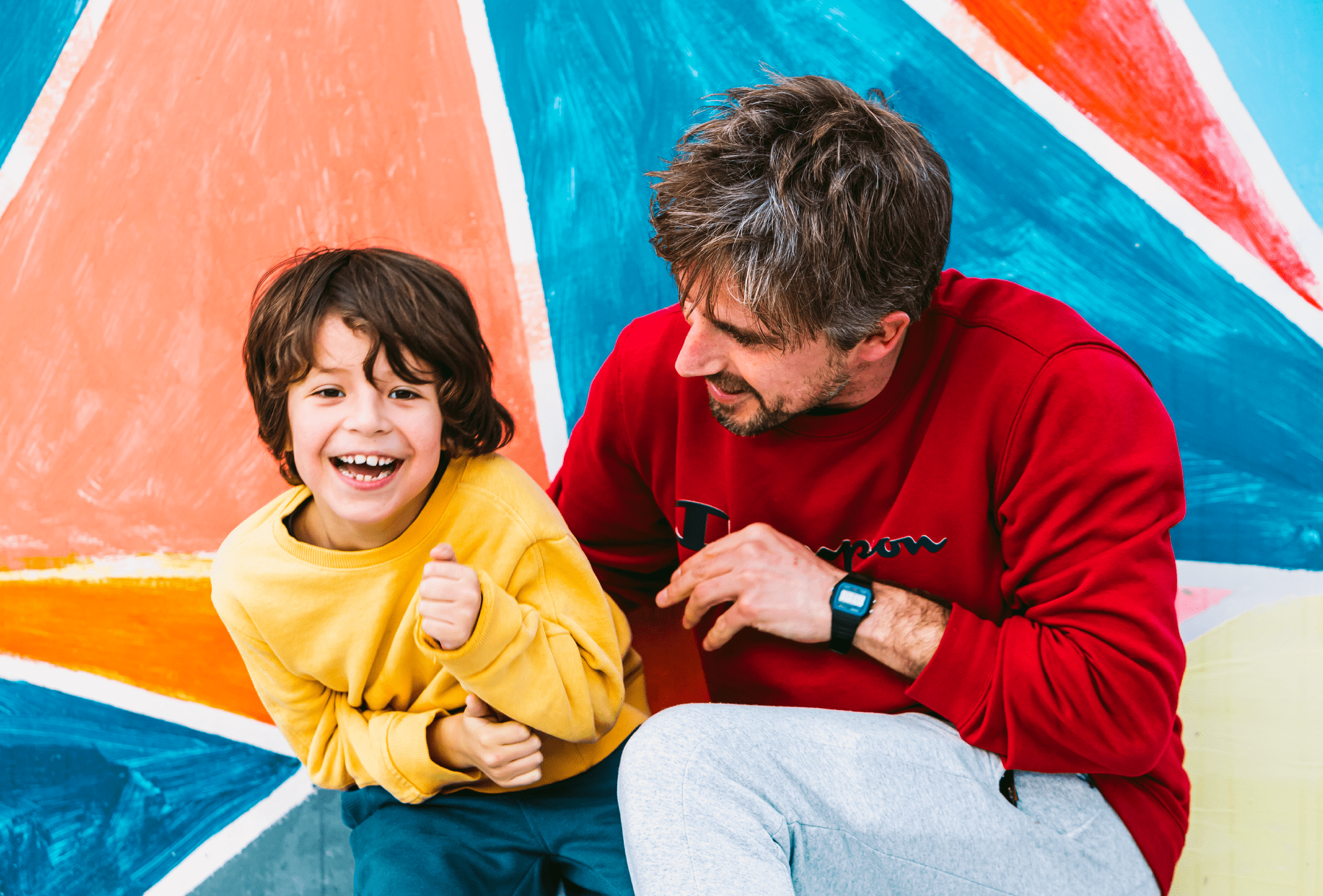 Profesional y niño sonriendo en un fondo colorido