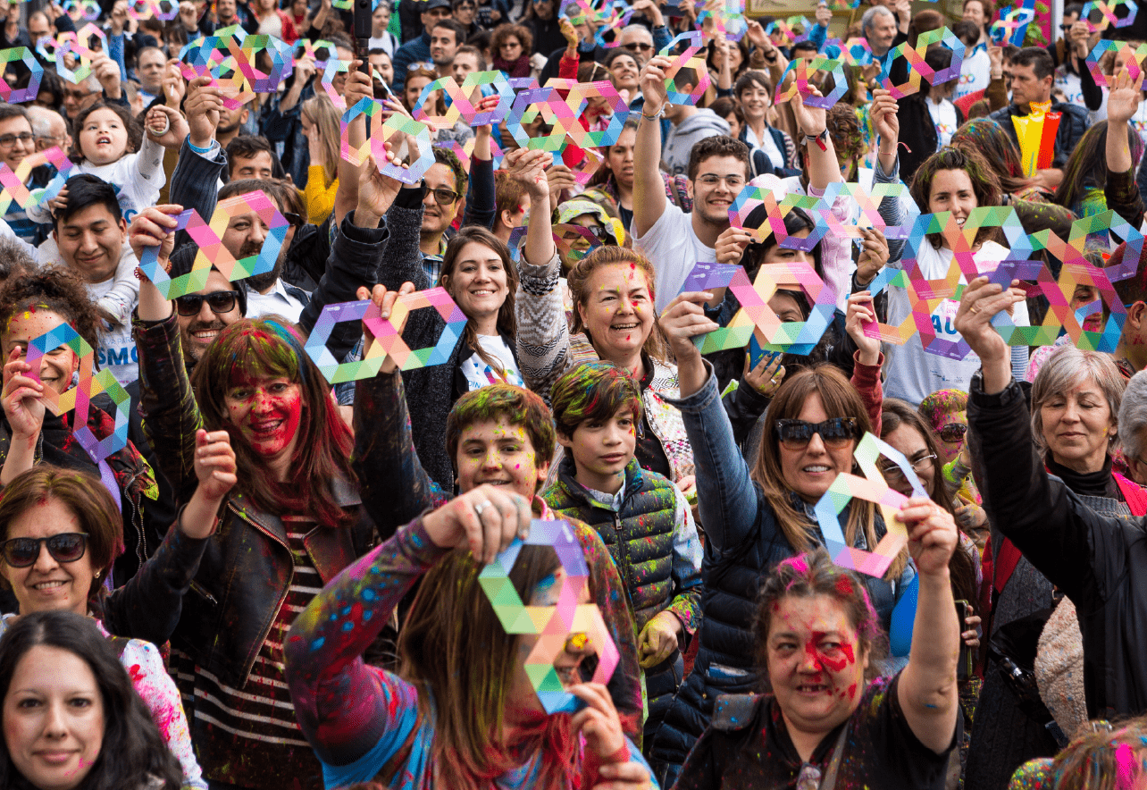 Grupo de personas sosteniendo el símbolo del infinito.