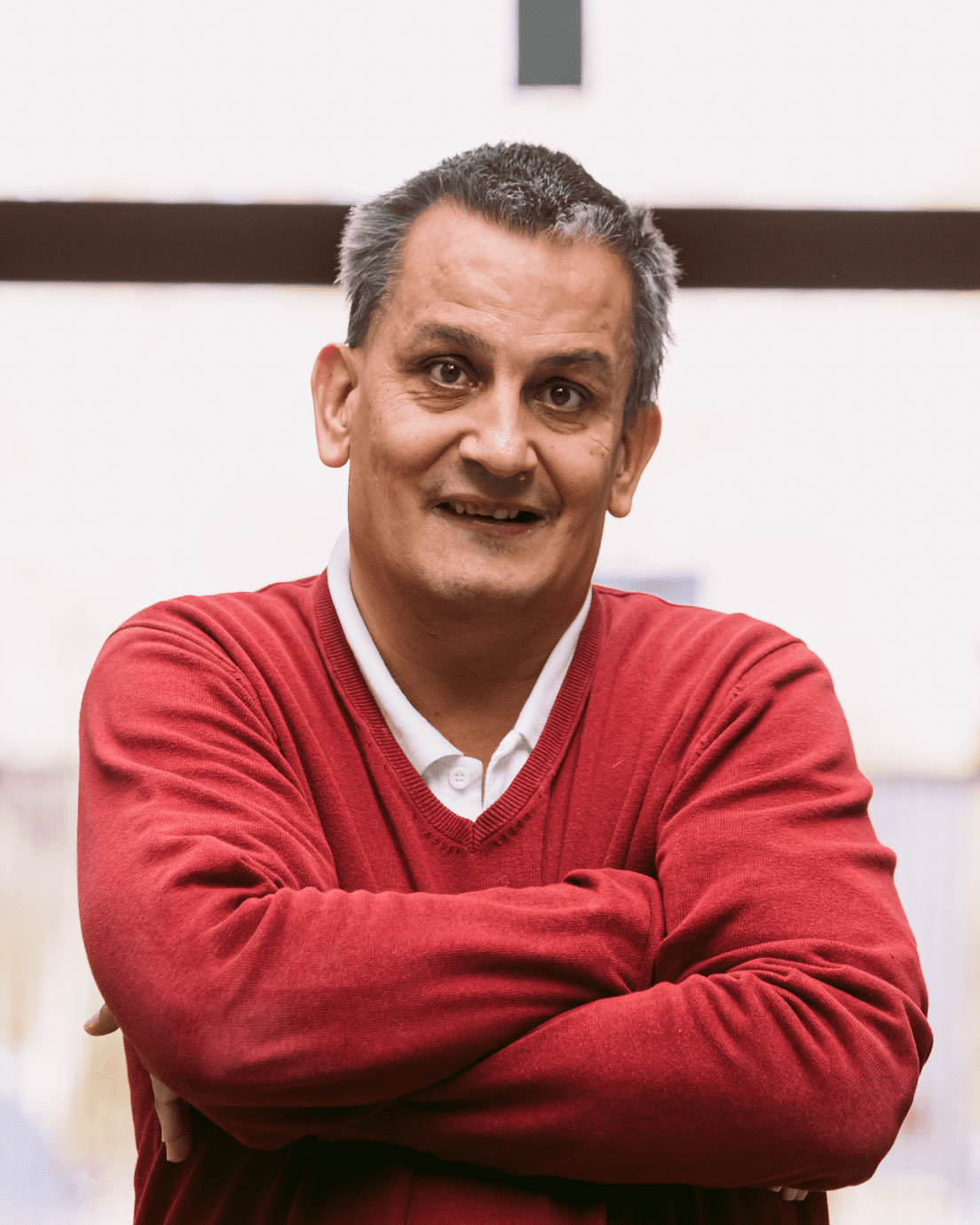 Hombre adulto sentado con los brazos cruzados.