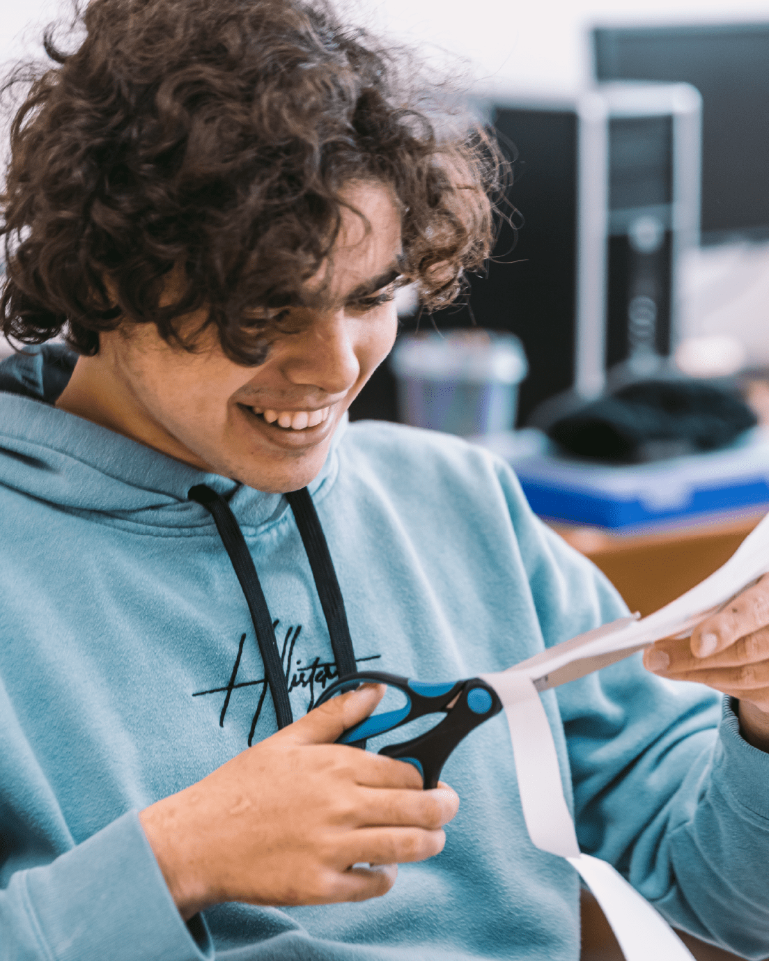 Chico con unas tijeras en la mano recortado.