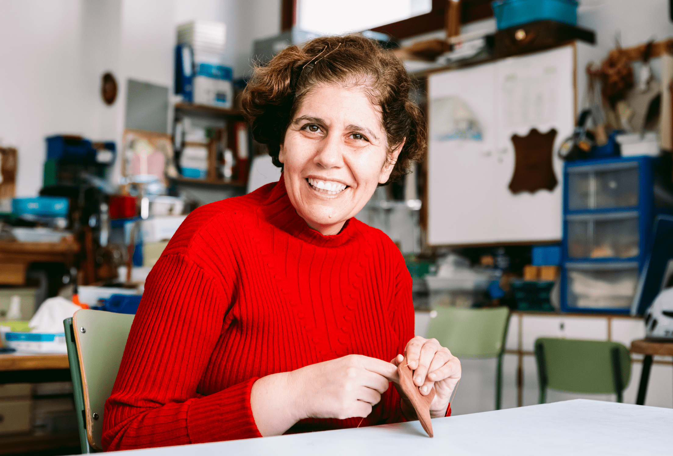 Mujer adulta autista trabajando cuero sonriendo.