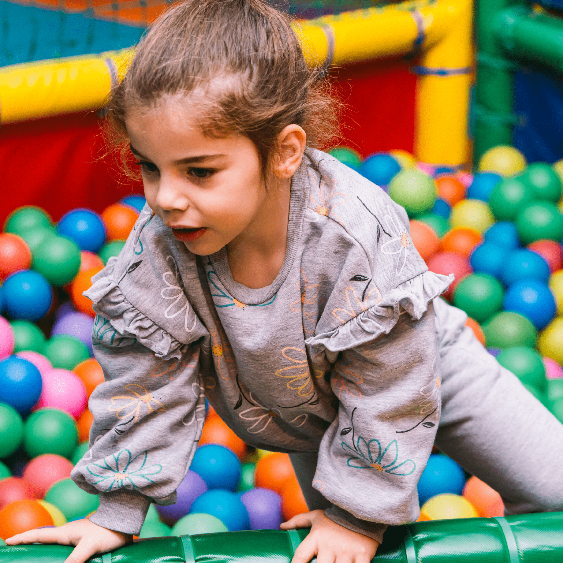 Niña jugando en una piscina de bolas infantil