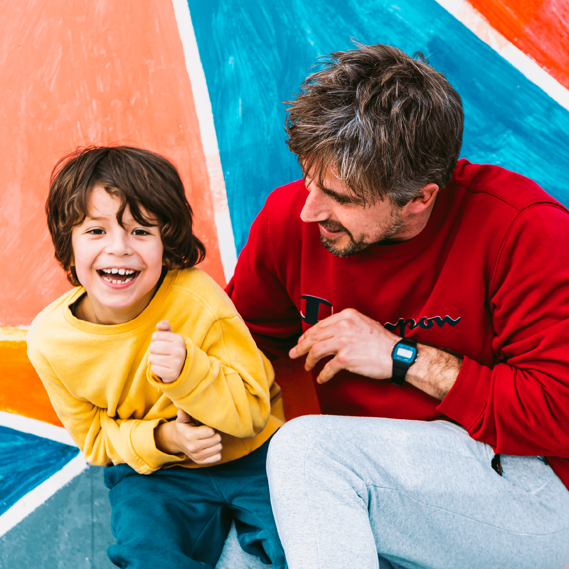 Un niño riendo abrazado por su padre