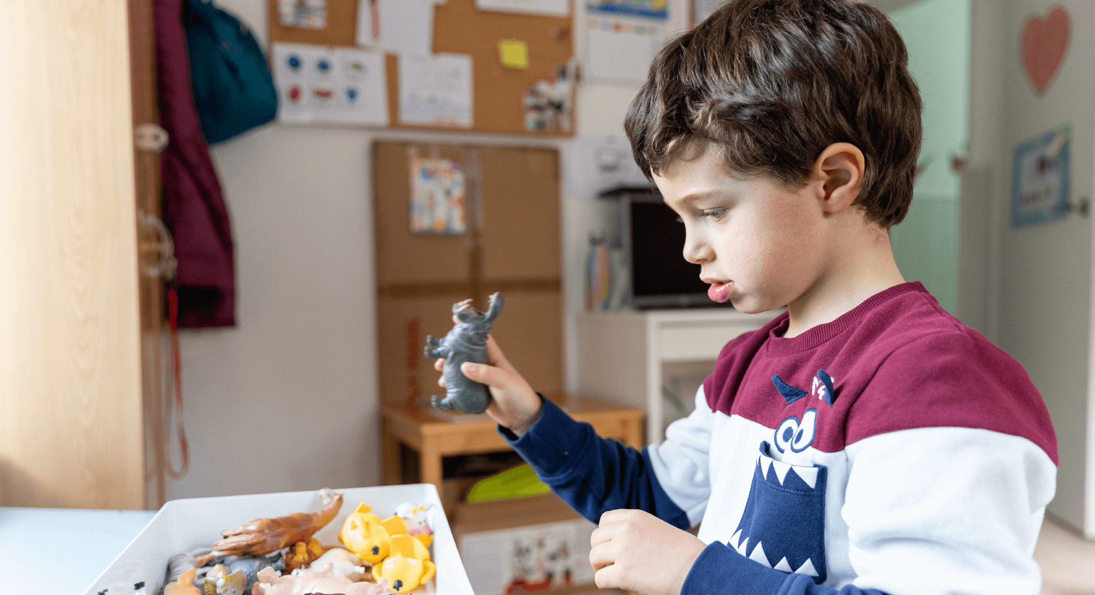 Imagen niño con juguete en la mano en clase