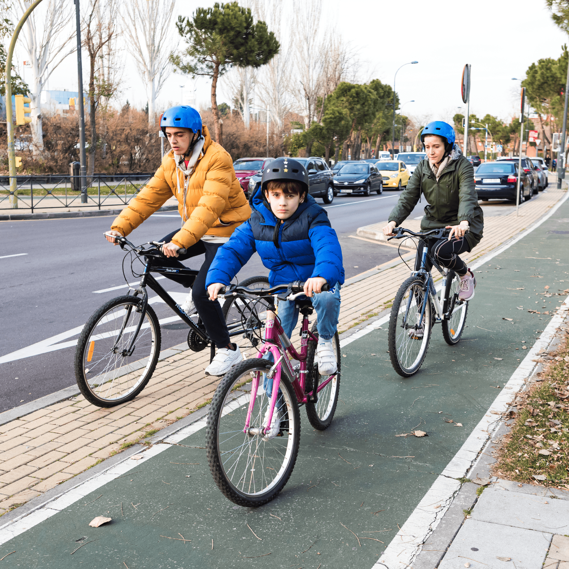 Grupo de tres personas autistas paseando con su bicicleta por el carril bici.