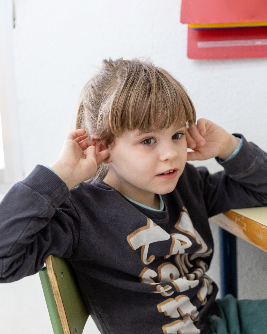 Niña sentada en su pupitre en un Aula TEA.
