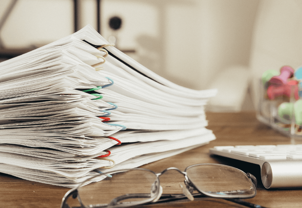 Mesa de escritorio con documentos en orden y gafas de ver
