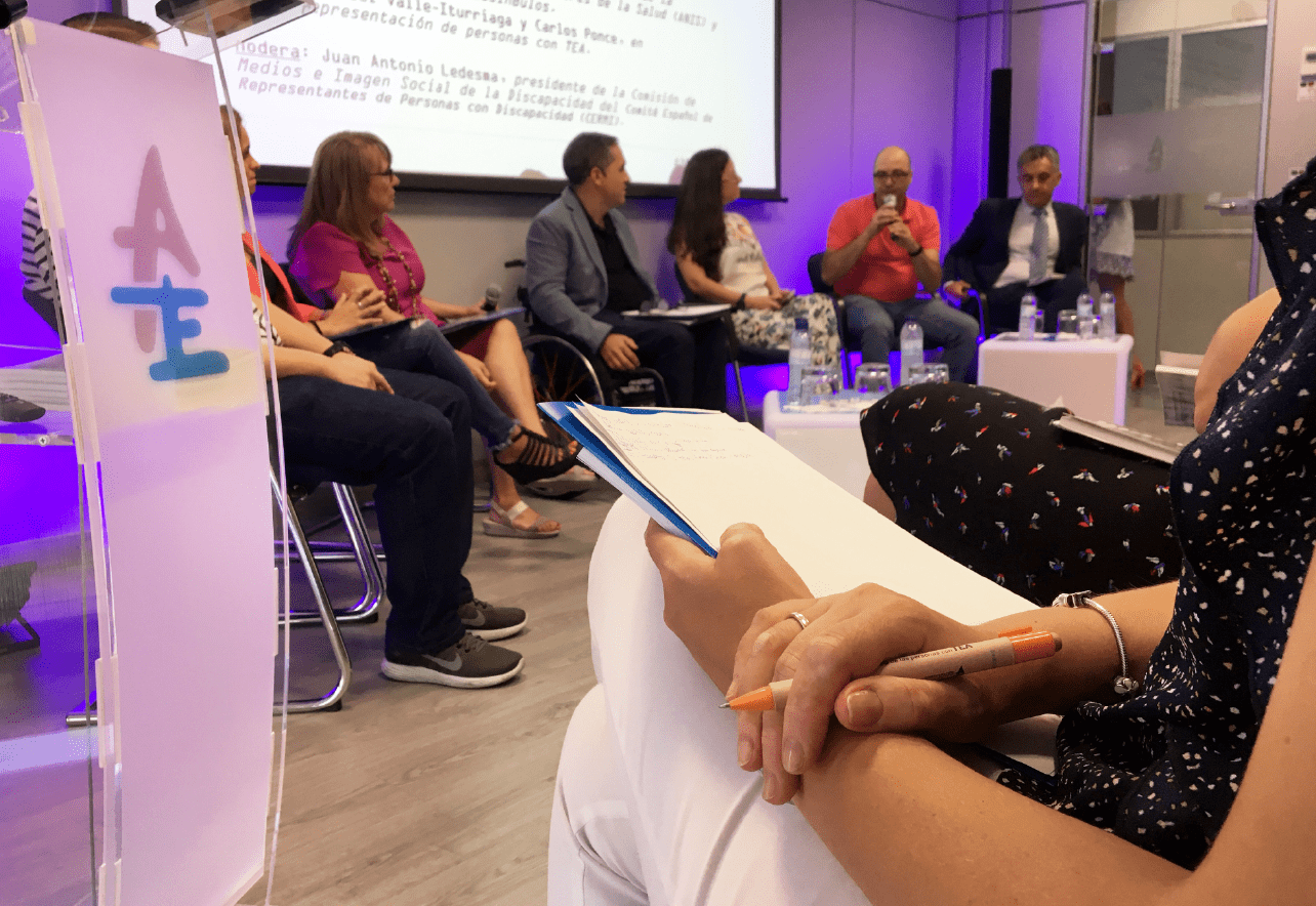 Fotografía de una reunión en la que hay varias personas sentadas tomando apuntes