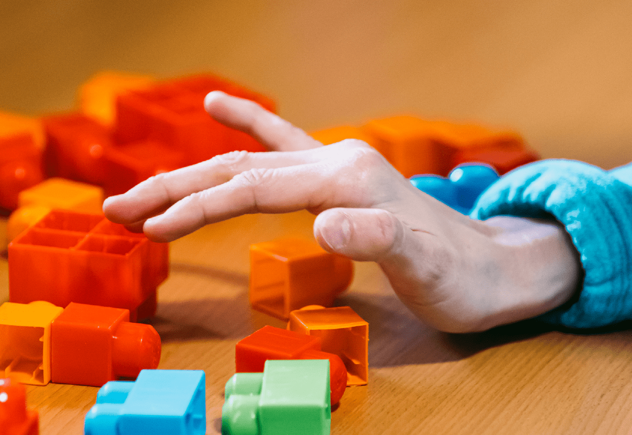 Mano interactuando con las piezas de un juego de bloques