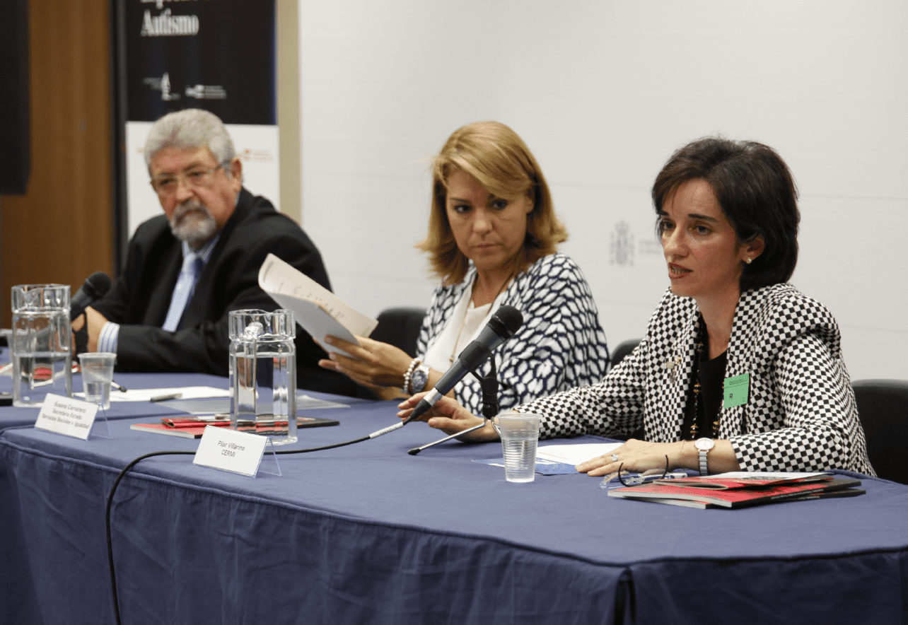 Tres personas sentadas dando una conferencia