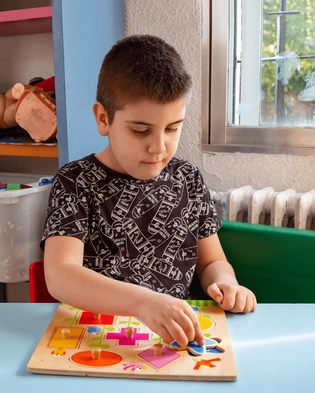 Niño concentrado en encajar las piezas de un juego de madera