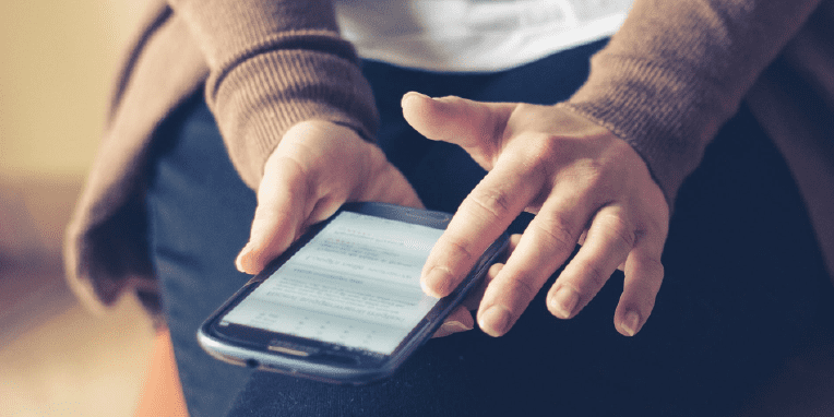 Miniatura de unas manos tocando un teléfono móvil