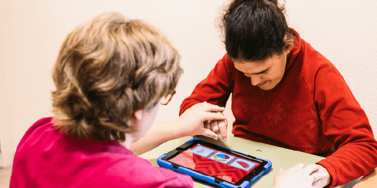 Miniatura de persona y facilitador utilizando una tablet para comunicarse