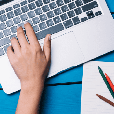 Imagen de una mano encima de un ordenador.