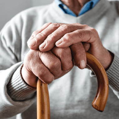 Dos manos adultas sujetando un bastón.