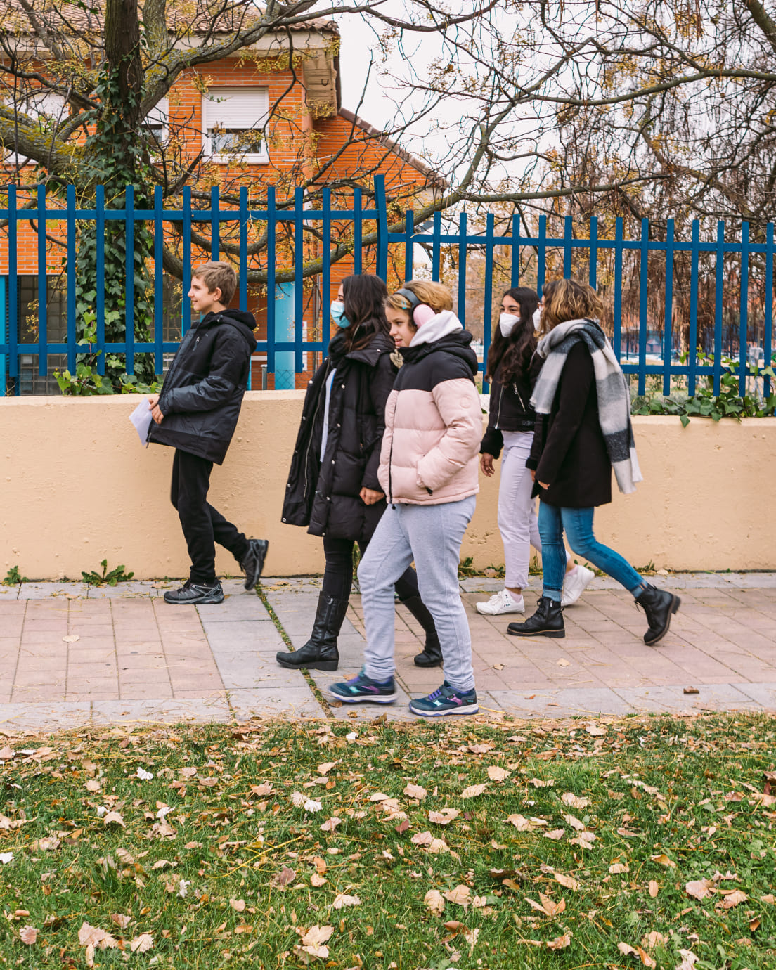 Chica con cascos caminando junto a otras personas jóvenes por la calle