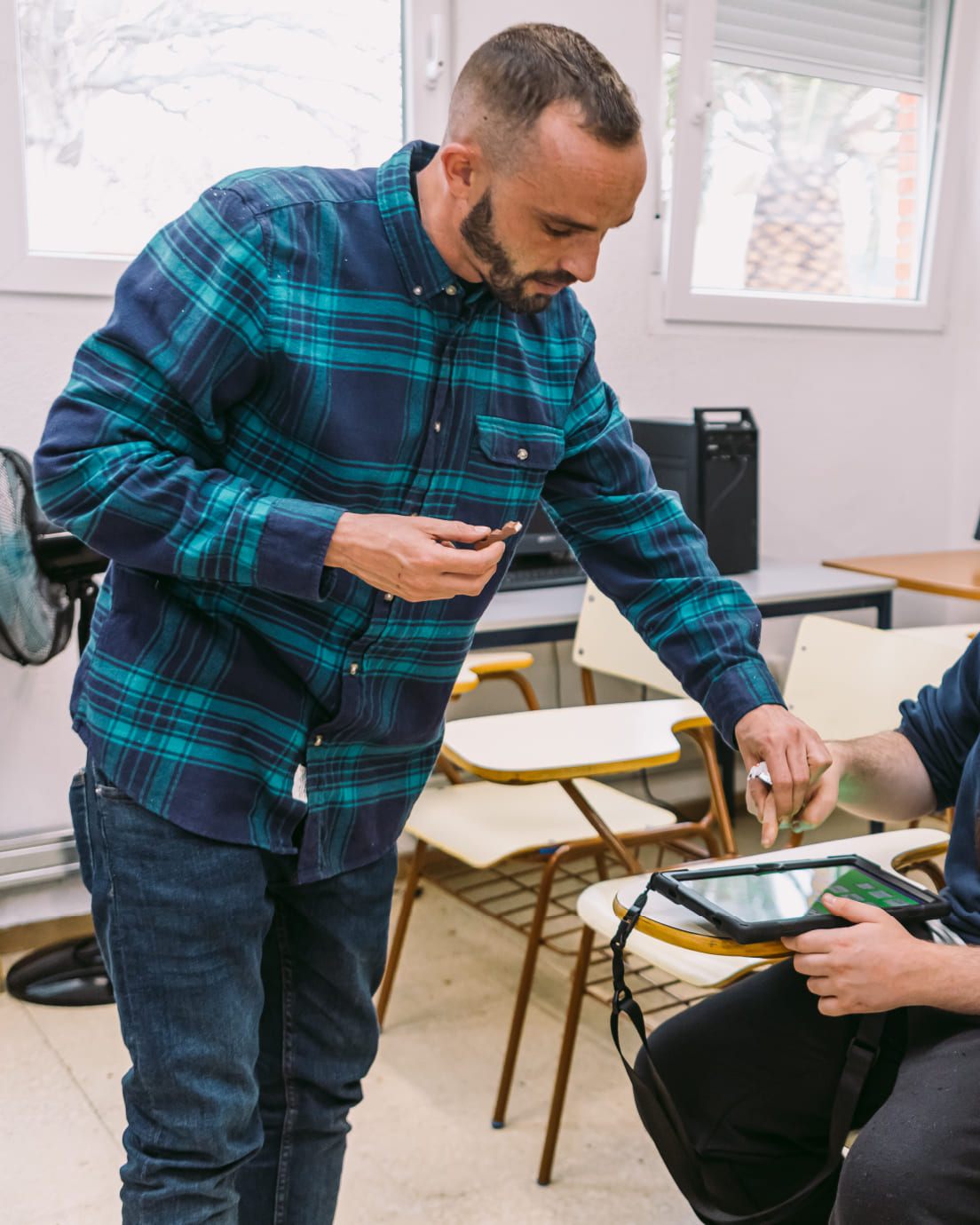 Hombre ayudando a un niño a usar una tablet
