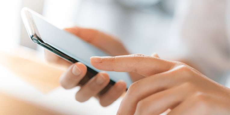 Imagen de unas manos sosteniendo un teléfono móvil