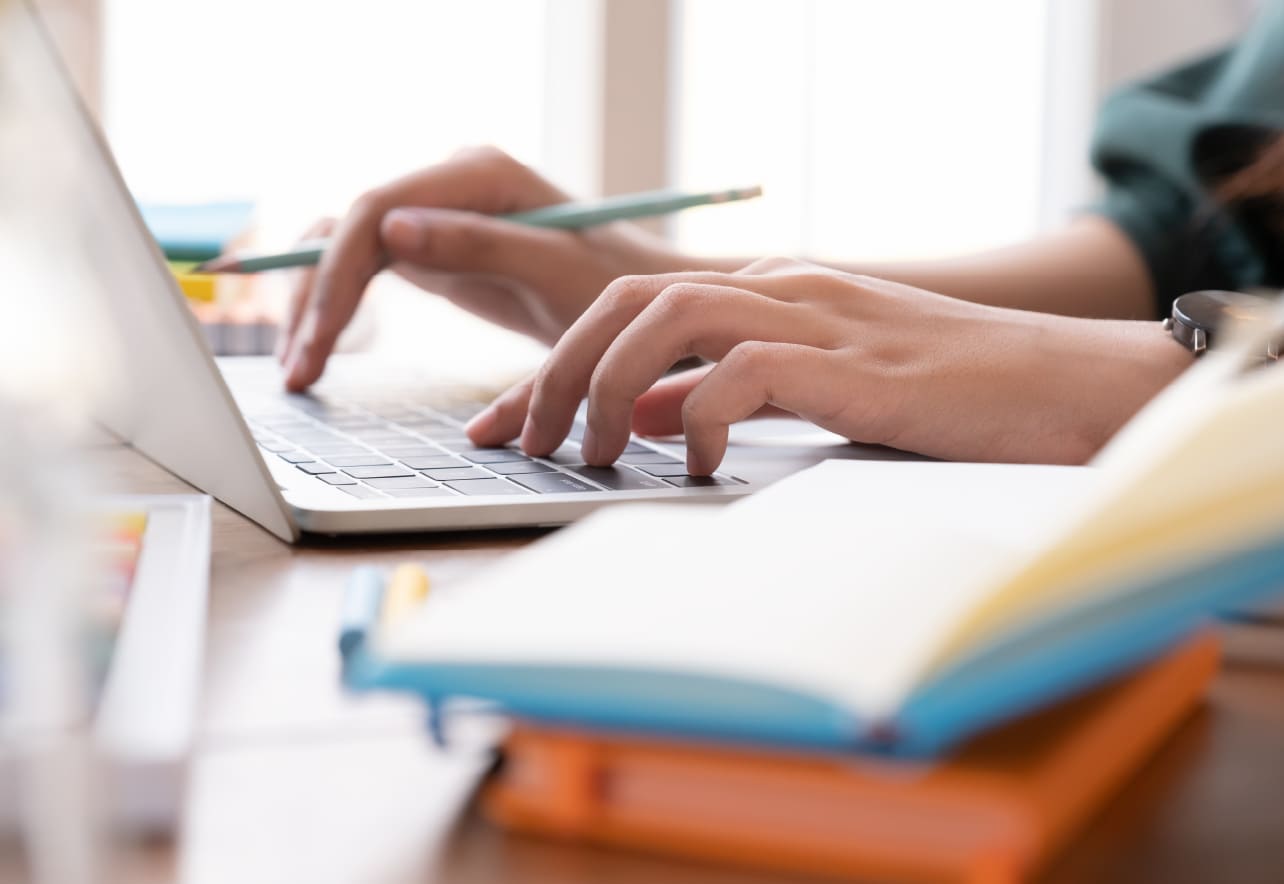 Unas manos de mujer tecleando en un ordenador portátil
