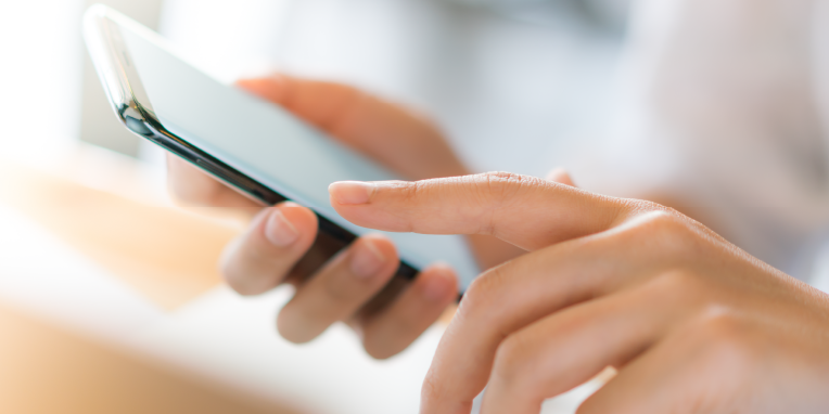 Miniatura de unas manos tocando un teléfono móvil