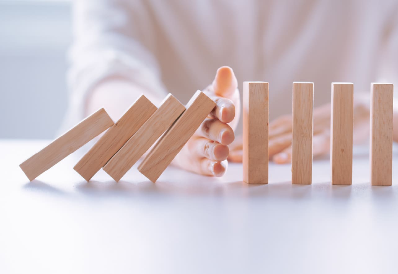 Miniatura de una figuras de madera sujetas por una mano de mujer
