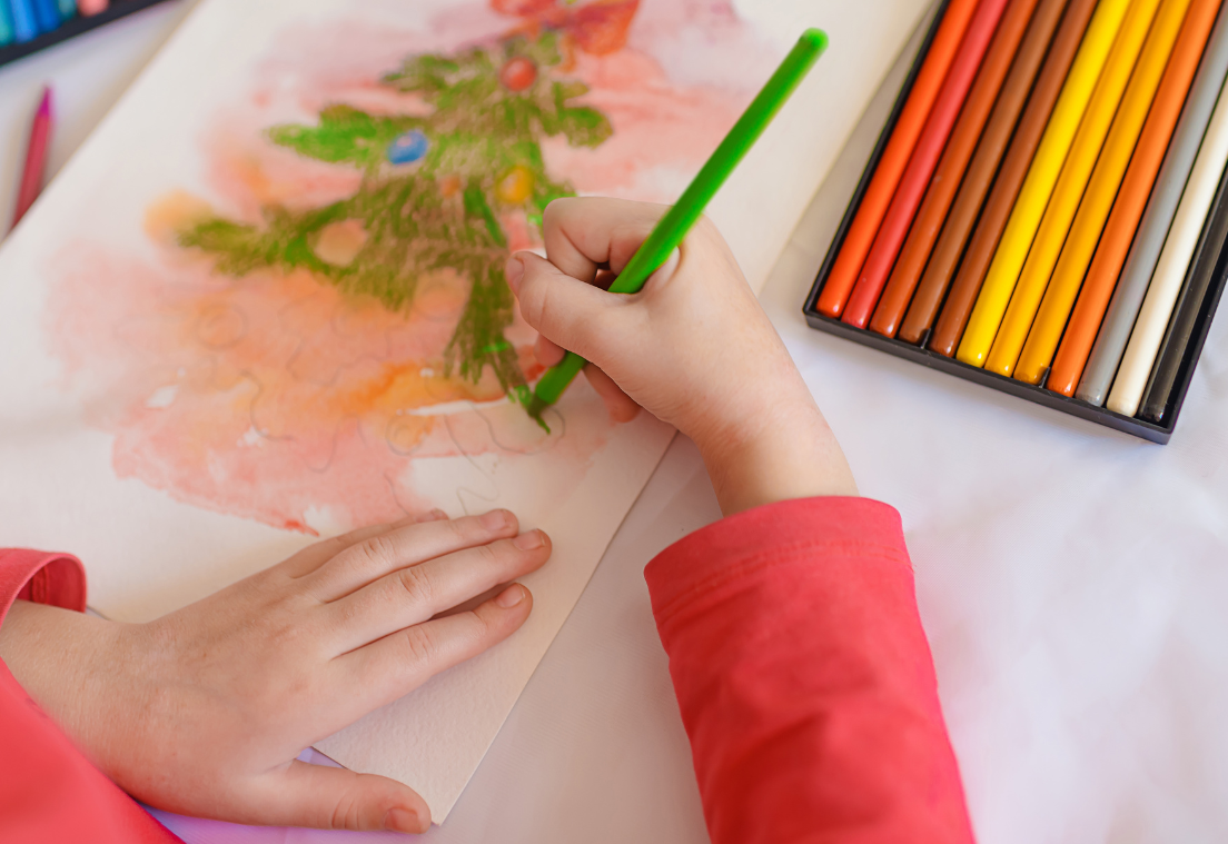 Mano coloreando un árbol de Navidad