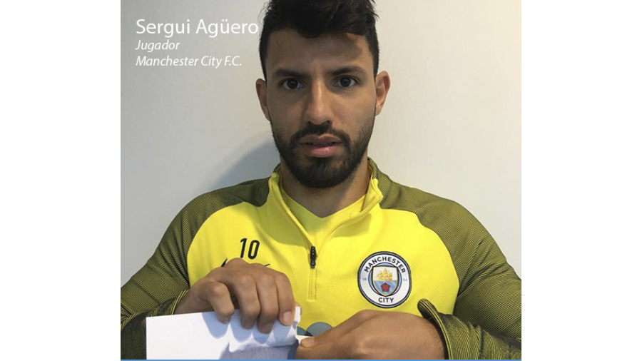El futbolista Sergio Agüero mirando a cámara y rompiendo un folio