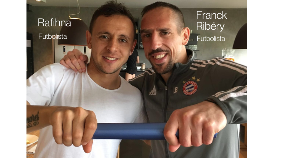 Dos futbolistas mirando a cámara sonriendo con un testigo azul en la mano