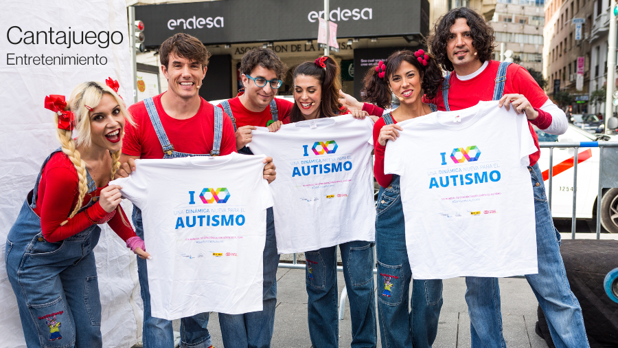 El grupo infantil Cantajuego posando con una camiseta con un infinito multicolor