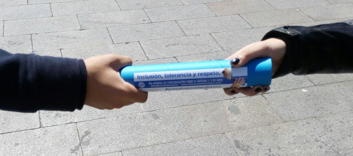 Dos manos sujetando un testigo azul