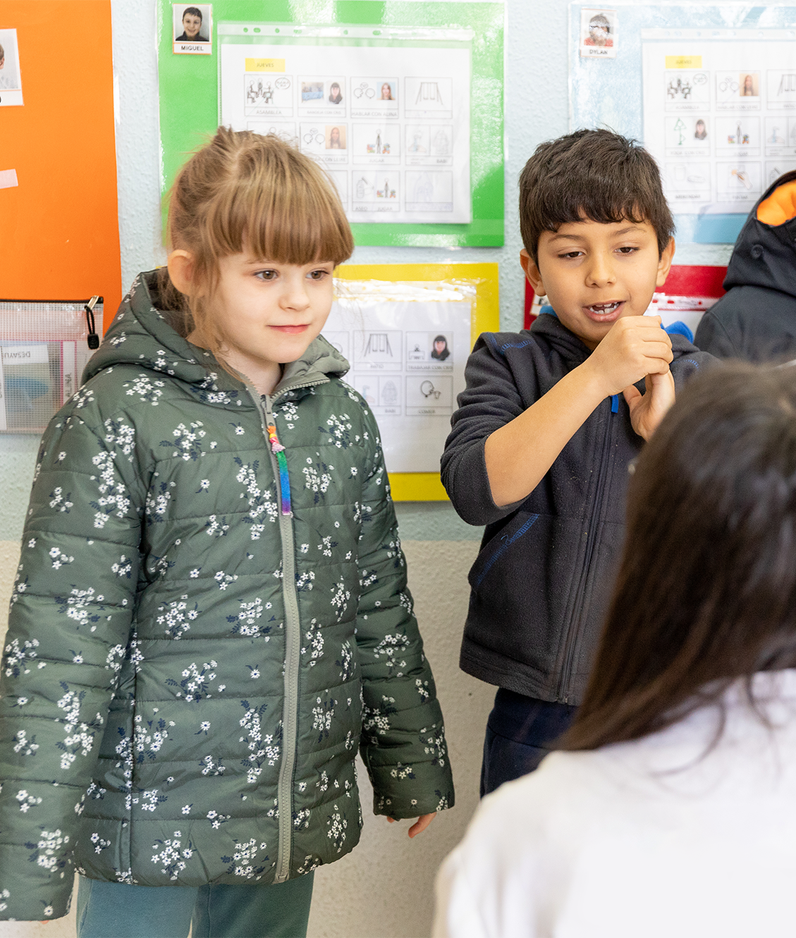 Dos alumnos en clase escuchando atentamente a su profesora.