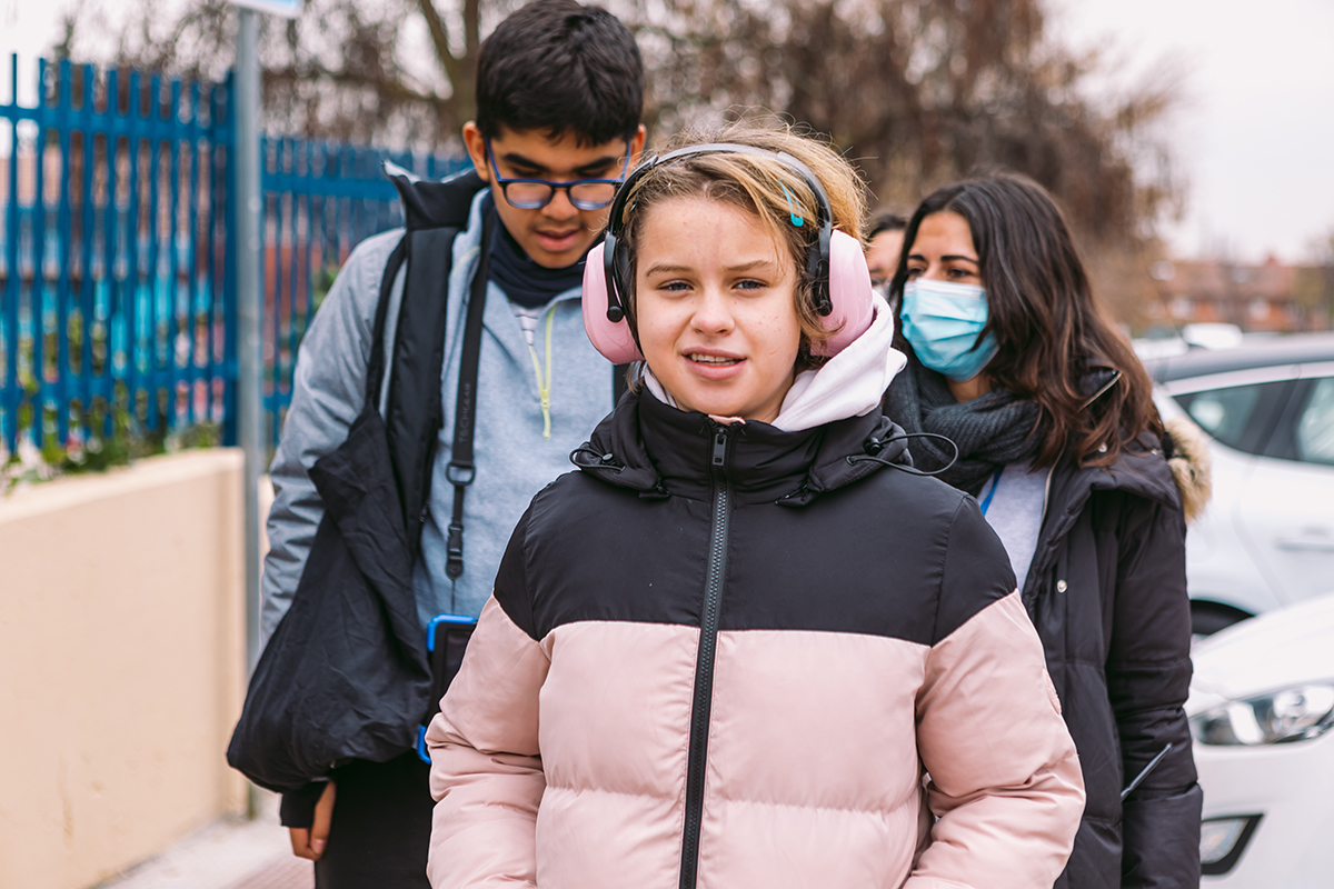 Niña autista paseando con compañeros de clase, con sus cascos antiruido