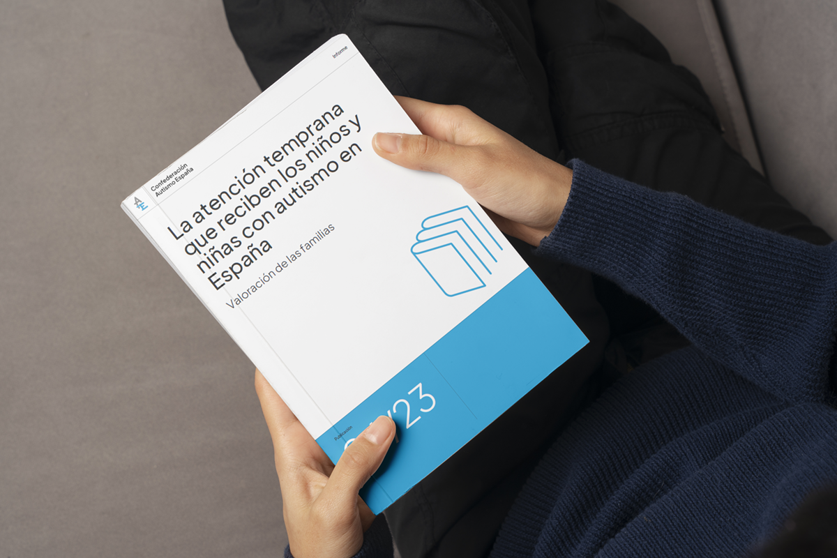 Unas manos sujetan un documento con el título: La atención temprana que reciben los niños y niñas con autismo en España. Valoración de las familias.