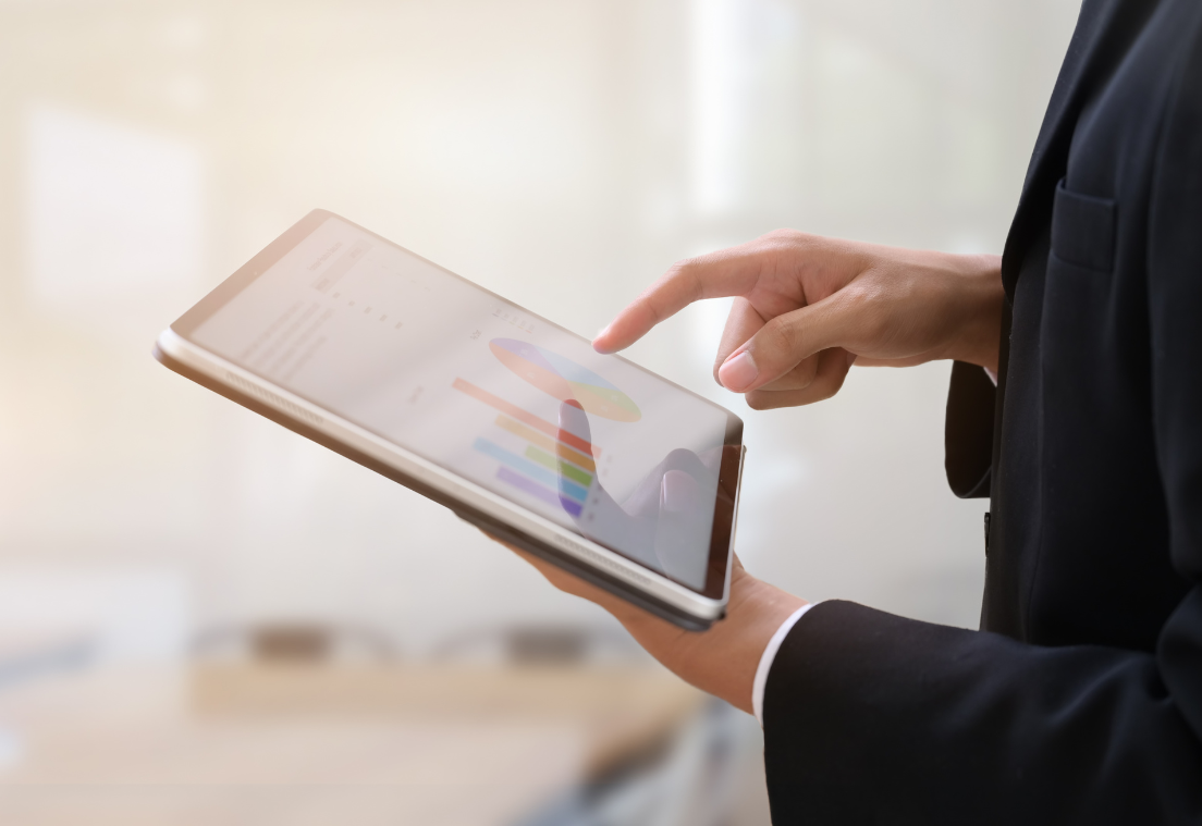 Una mujer sujetando una tablet en la que aparecen gráficos