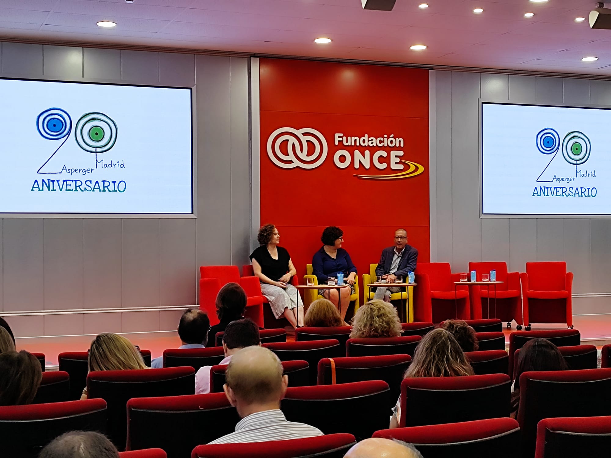 Imagen de tres personas sentadas participando en la jornada del XX aniversario de Asperger Madrid