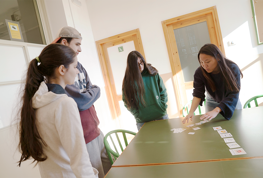 Un grupo de personas autistas en una clase viendo pictogramas