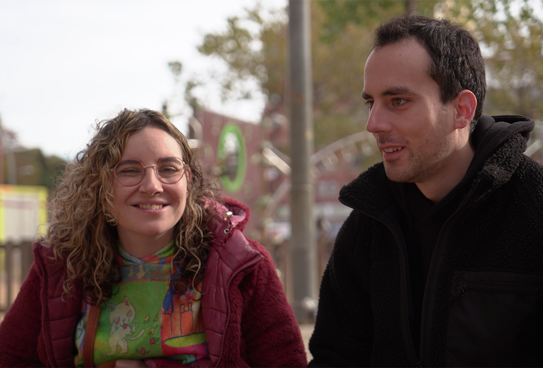 Chica autista sonriente mirando a la cámara junto a un chico autista