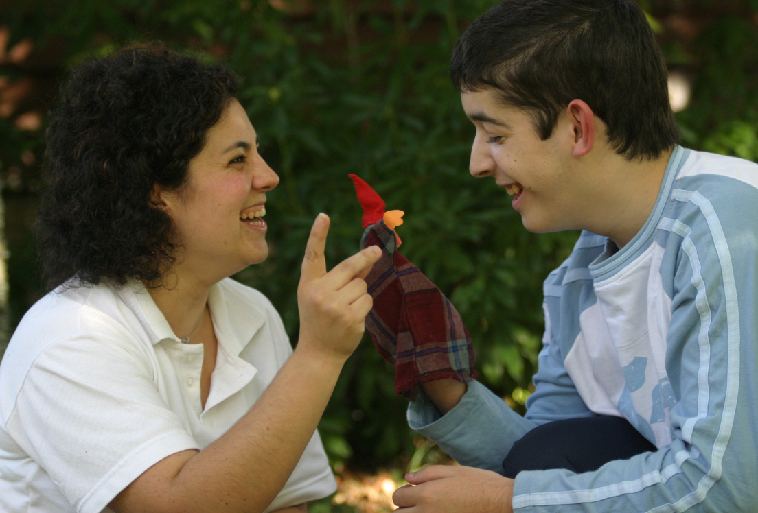 Una mujer trabajando como profesional de apoyo junto con un chico autista