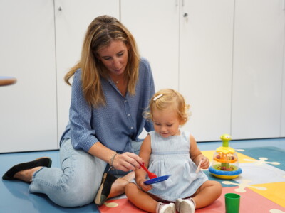Madre arrodillada en el suelo junto a su hija