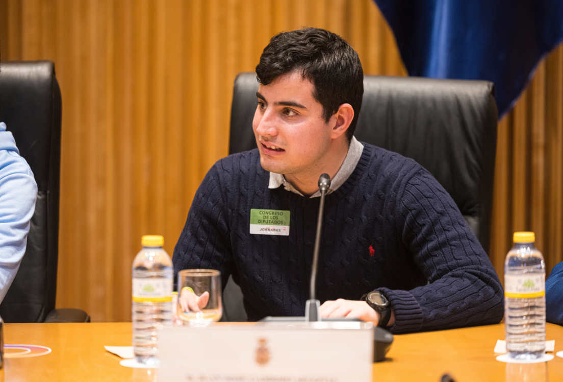 Adolescente sentado en una silla hablando a través de u micrófoonoo