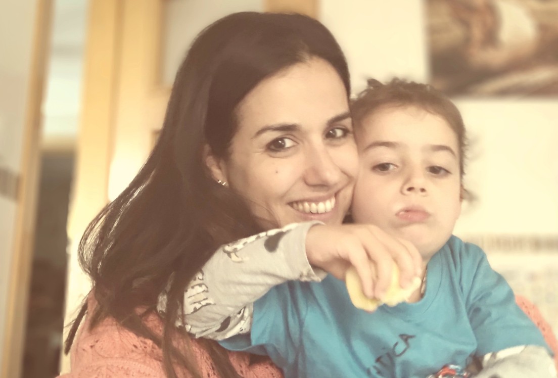 Una madre abraza a su hija mirando a cámara