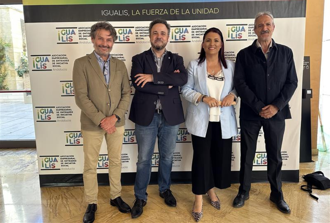 tres hombres y una mujer delante de un photocall posando para la cámara.